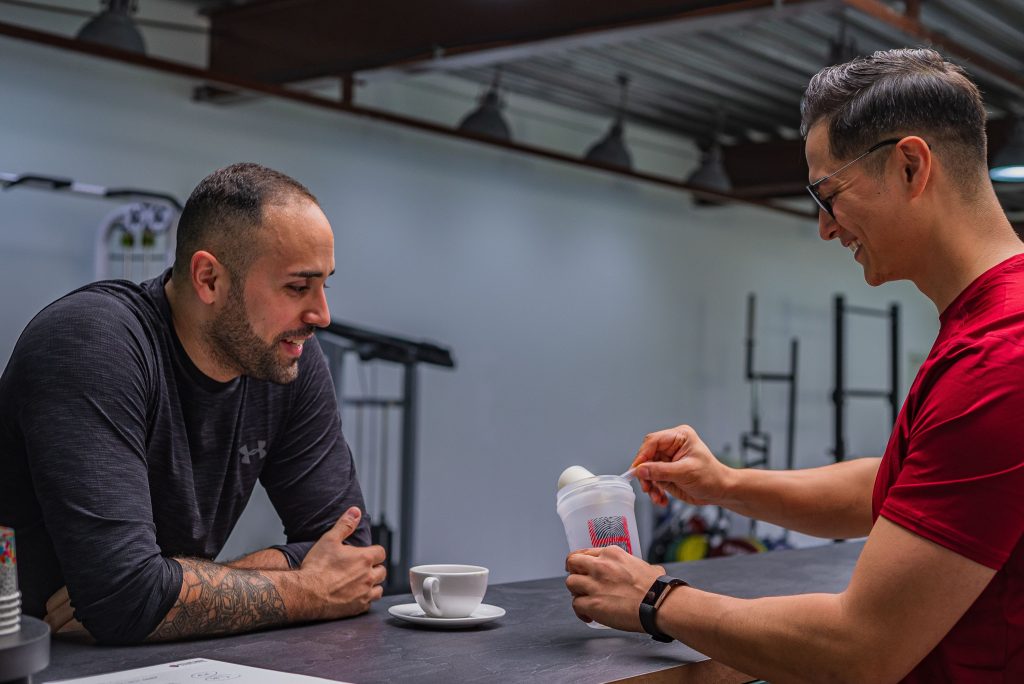 Two adults measuring protein powder